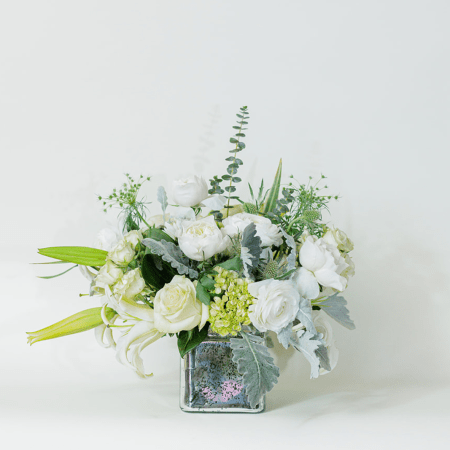 Elegant, fresh, and full of grace, this stunning arrangement brings together soft whites and subtle greens for a truly refined look.