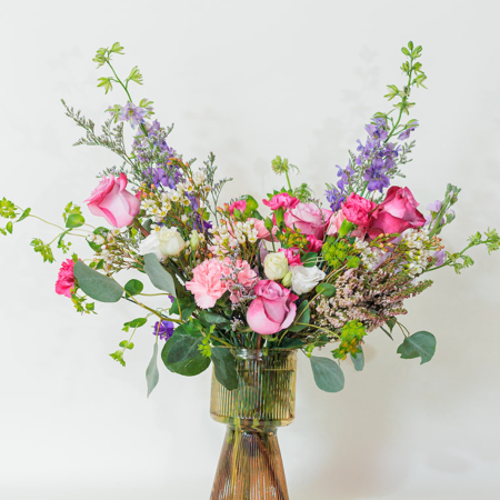 This serene and elegant arrangement features four soft lavender roses, symbolizing love and calm, surrounded by the regal purple larkspur that evokes deep emotion.
