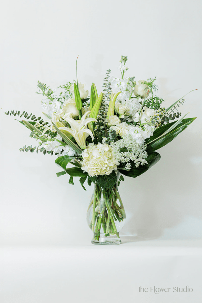 Timeless elegance takes center stage in this stunning tall floral arrangement, where pure white blooms create a breathtaking display of grace.