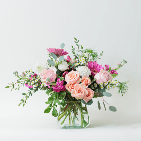 This enchanting flower arrangement is a lovely combination of soft, romantic hues and vibrant pops of color, creating a fresh and elegant design.